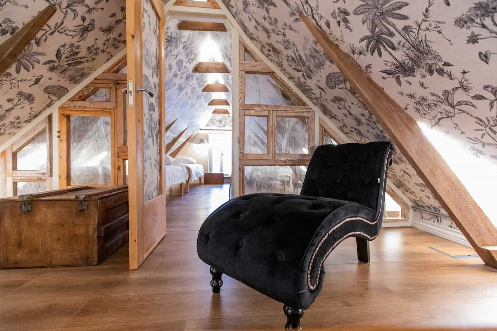 a black chair sitting in a room under a slanted ceiling