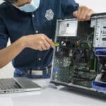 A Man Wearing a Face Mask Repairing a CPU