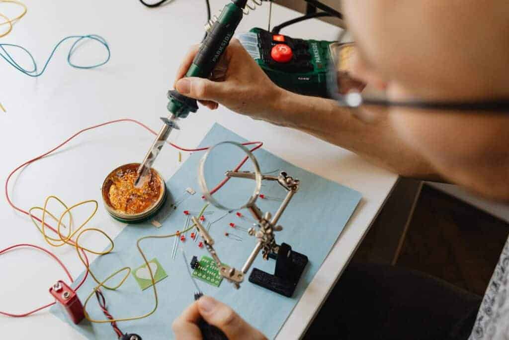 A Person Dipping a Soldering Iron on a Solder Flux