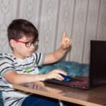 man in black and white stripe shirt using black laptop computer