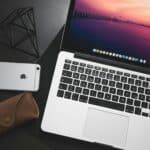 MacBook Pro beside space iPhone 6 on black wooden surface