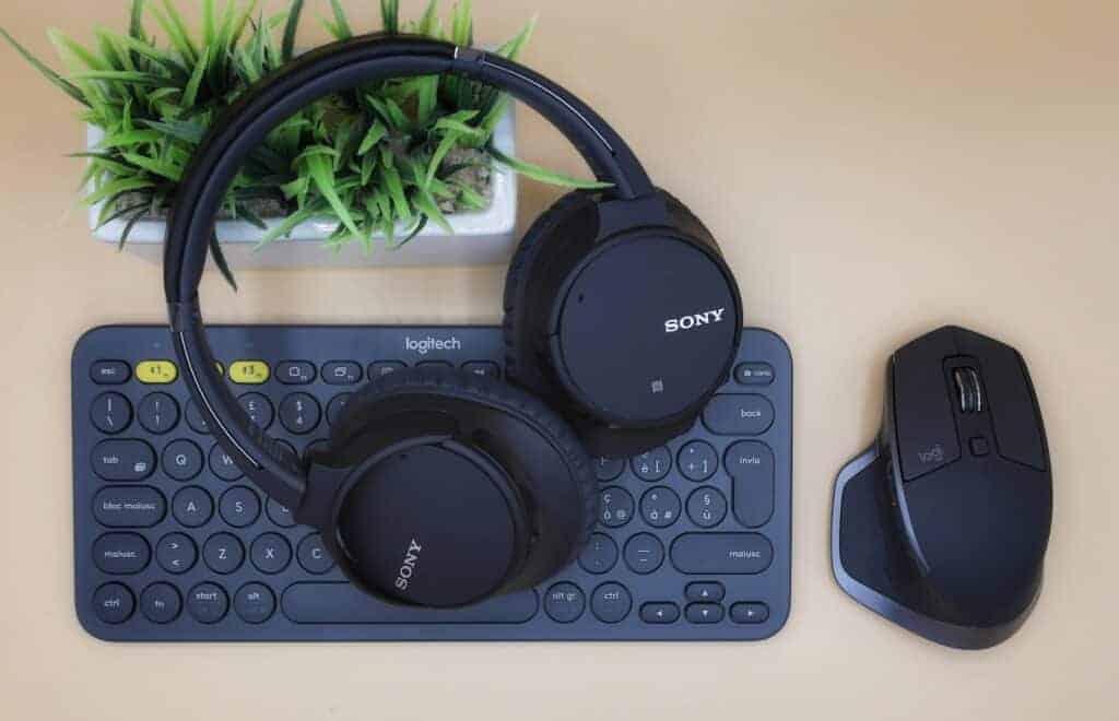 black Sony wireless headphones on black computer keyboard