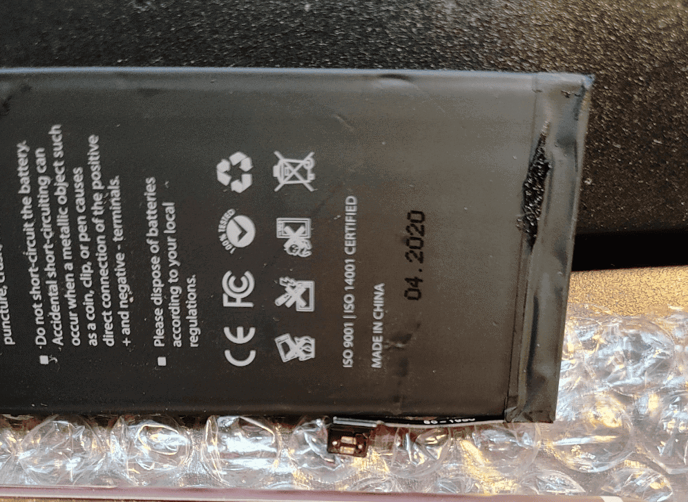 a black battery with white text and symbols on it