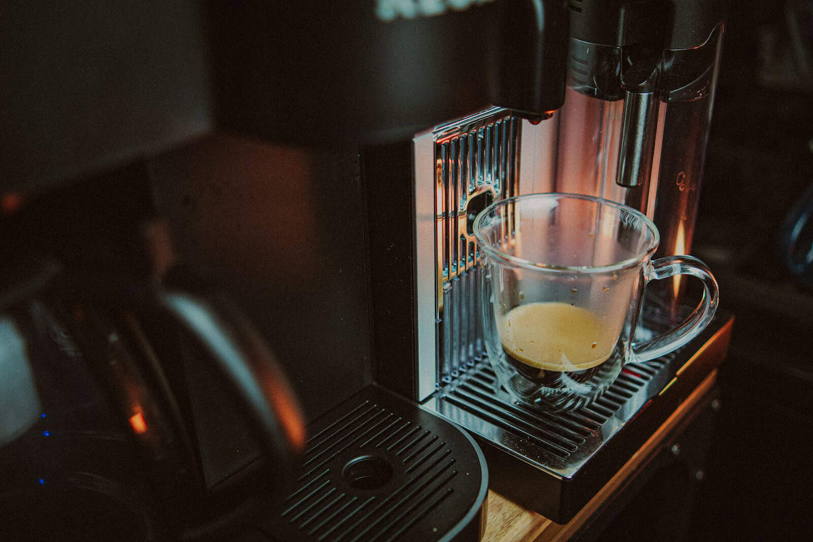 a glass of liquid on a coffee machine